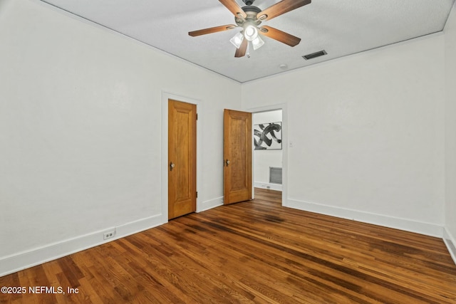 spare room featuring ceiling fan, dark hardwood / wood-style floors, and a textured ceiling