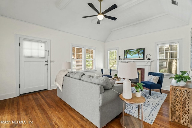 living room featuring ceiling fan, lofted ceiling, dark hardwood / wood-style flooring, and a brick fireplace