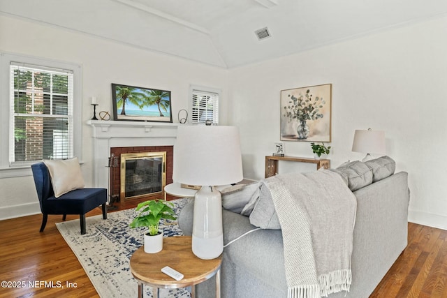 living room featuring hardwood / wood-style flooring, a fireplace, and vaulted ceiling