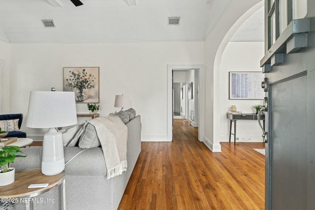 living room featuring dark wood-type flooring and ceiling fan