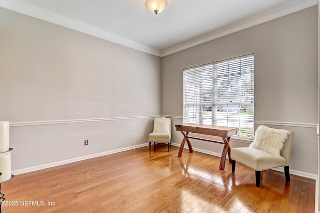 living area with baseboards, wood finished floors, and crown molding