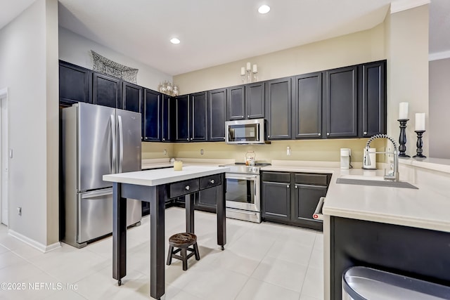 kitchen featuring a sink, dark cabinetry, recessed lighting, appliances with stainless steel finishes, and light countertops