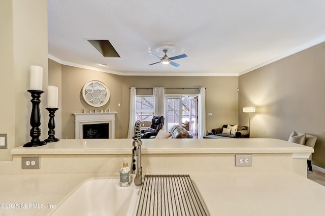 interior space with a ceiling fan, baseboards, a fireplace, ornamental molding, and open floor plan