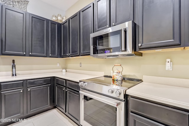 kitchen featuring light tile patterned floors, appliances with stainless steel finishes, and light countertops