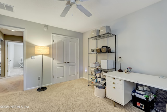 office space featuring visible vents, light colored carpet, baseboards, and ceiling fan