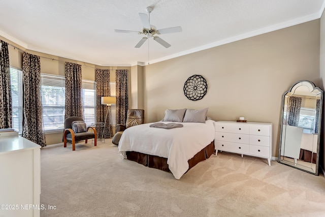 bedroom with a ceiling fan, baseboards, light colored carpet, and crown molding