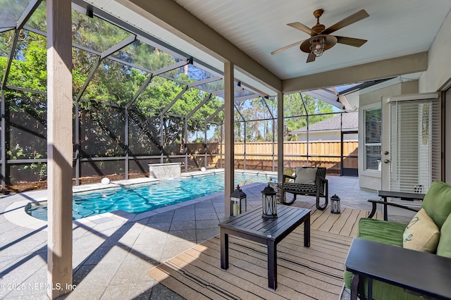 view of pool featuring glass enclosure, fence, a fenced in pool, and a ceiling fan