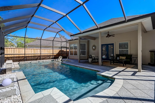 view of swimming pool featuring french doors, a patio, ceiling fan, and glass enclosure