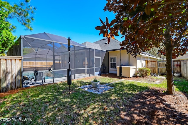 view of yard featuring a lanai, an outdoor pool, and a fenced backyard