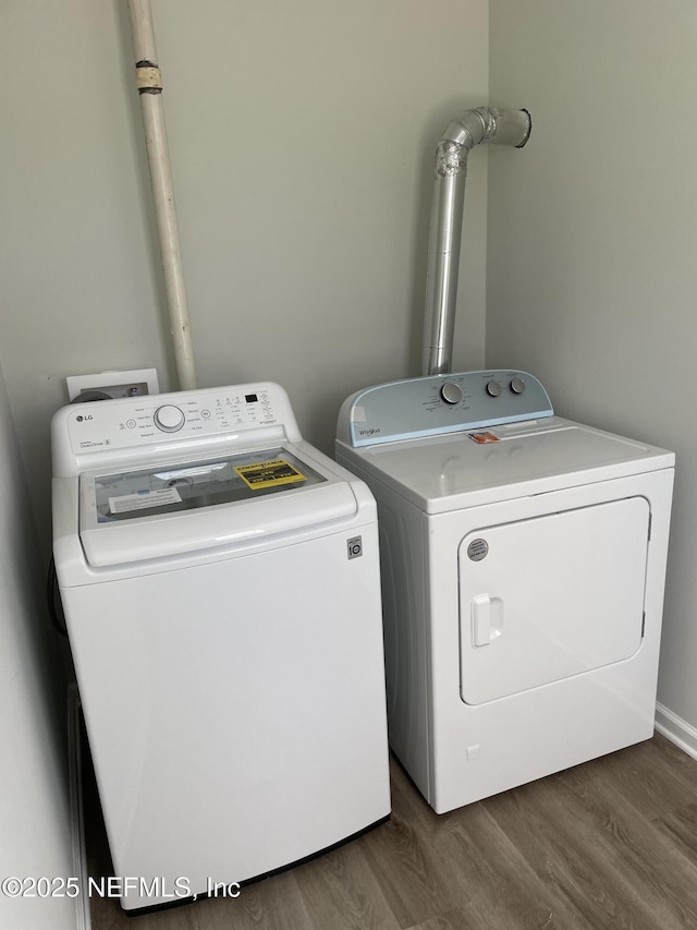 clothes washing area with dark hardwood / wood-style floors and washing machine and clothes dryer