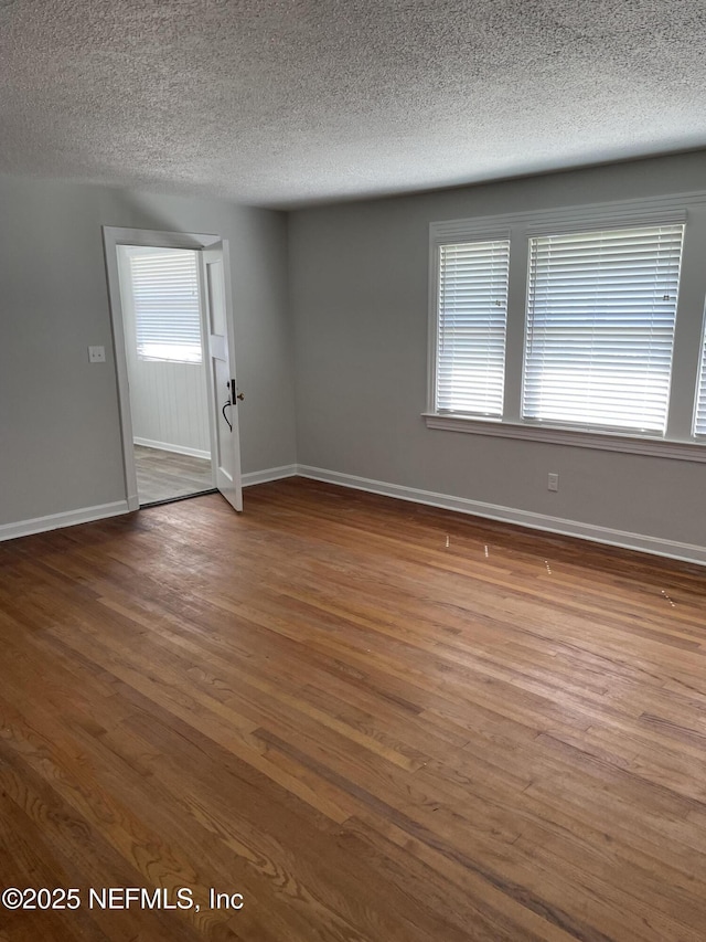 spare room with hardwood / wood-style flooring and a textured ceiling