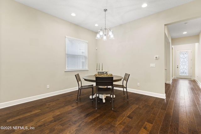 dining room featuring dark wood-type flooring and an inviting chandelier