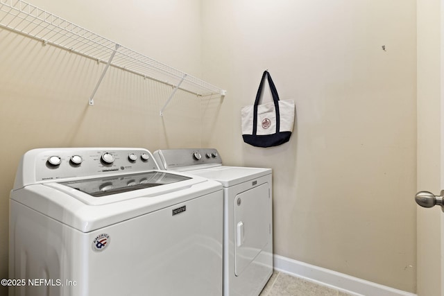 laundry area featuring light tile patterned floors and washer and clothes dryer