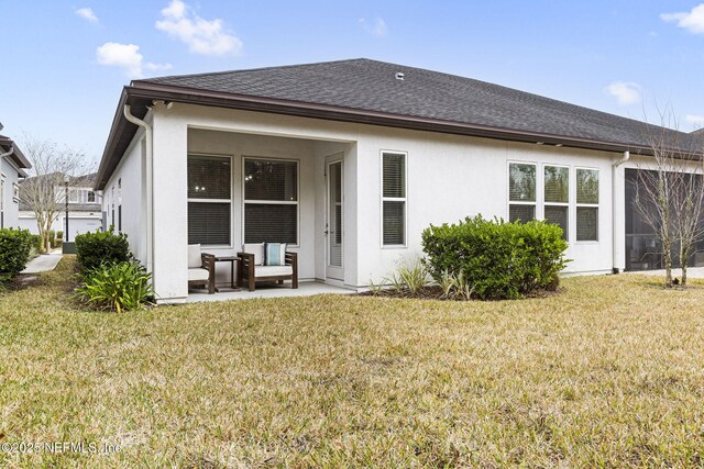 back of house featuring a lawn and a patio