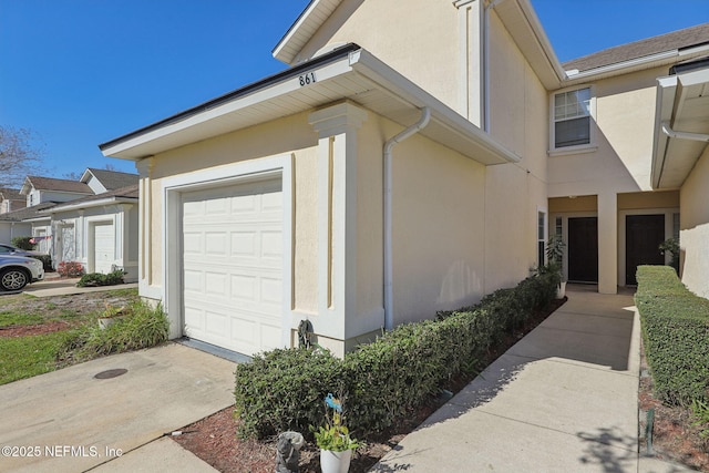 view of side of home with a garage and stucco siding