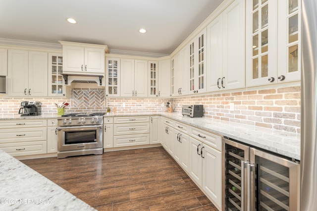 kitchen featuring light stone countertops, appliances with stainless steel finishes, beverage cooler, and backsplash