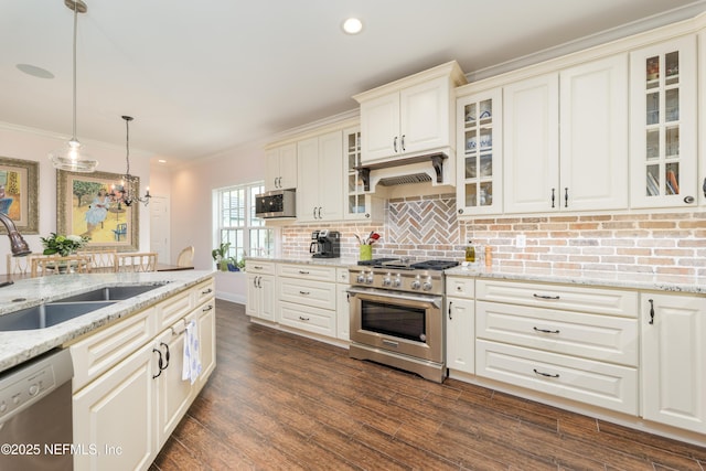 kitchen featuring pendant lighting, sink, premium range hood, appliances with stainless steel finishes, and light stone counters