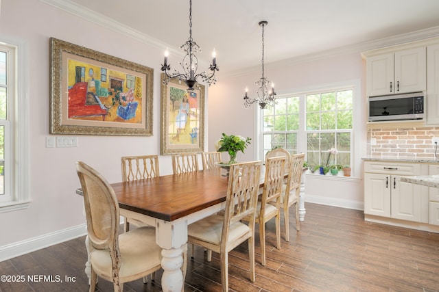 dining space featuring crown molding, dark hardwood / wood-style flooring, and an inviting chandelier