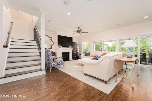 living room featuring crown molding, dark wood-type flooring, and ceiling fan