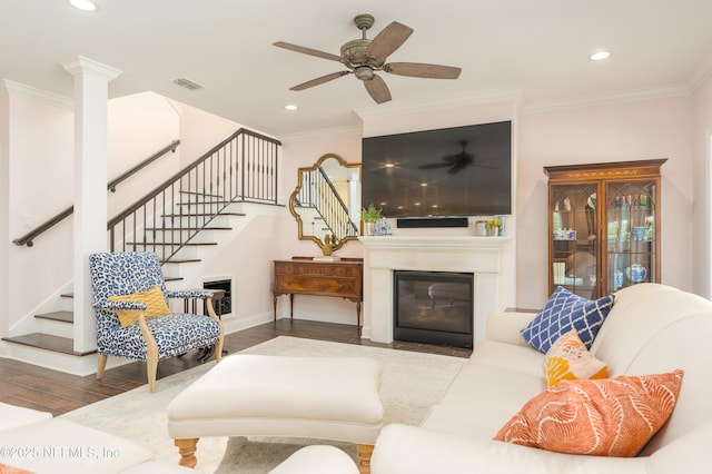 living room featuring wood-type flooring, ornamental molding, and ceiling fan