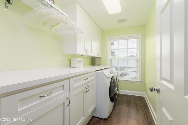 laundry room with dark wood-type flooring, cabinets, and washing machine and dryer