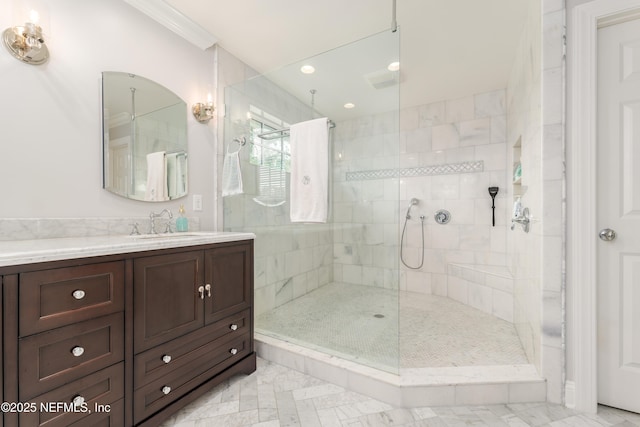 bathroom featuring a tile shower, vanity, and crown molding