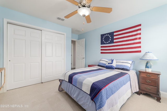 bedroom featuring light colored carpet, a closet, and ceiling fan