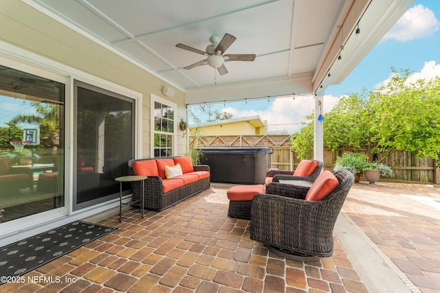 view of patio with a hot tub, an outdoor living space, and ceiling fan