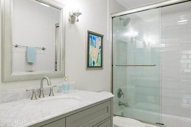 full bathroom with vanity, toilet, and combined bath / shower with glass door