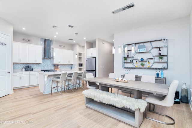 dining space with sink and light wood-type flooring