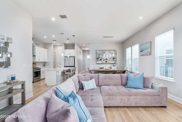 living room featuring sink and light wood-type flooring