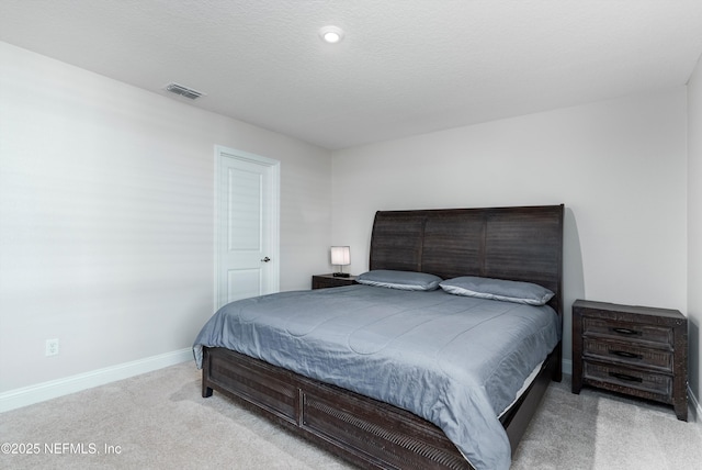 bedroom with light carpet and a textured ceiling