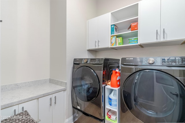 laundry area featuring independent washer and dryer and cabinets