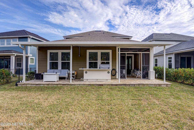 rear view of house with an outdoor living space, a patio, and a lawn