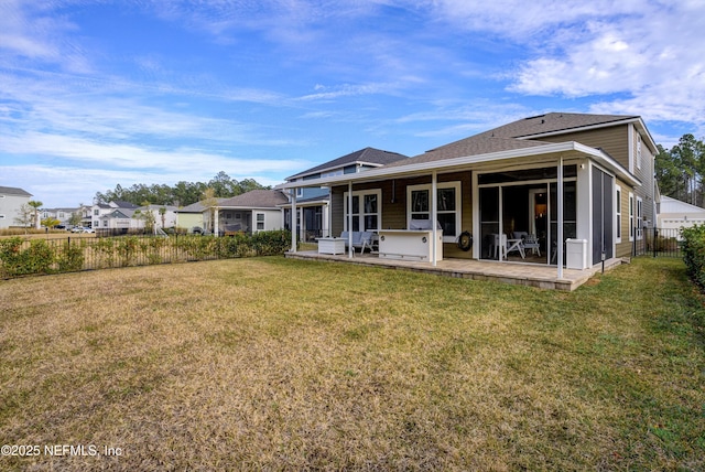 rear view of house with a hot tub, a sunroom, a yard, and a patio area