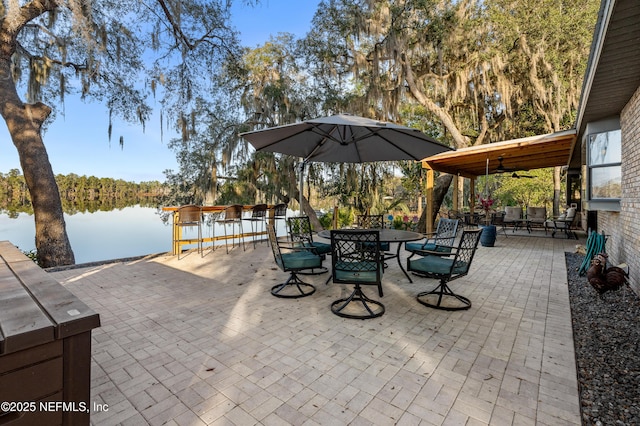 view of patio with ceiling fan and a water view