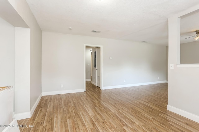 spare room featuring ceiling fan, a textured ceiling, and light wood-type flooring