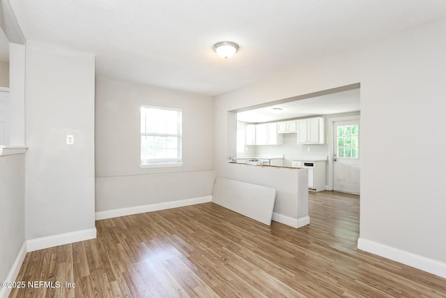 kitchen with light hardwood / wood-style flooring, white cabinets, and kitchen peninsula