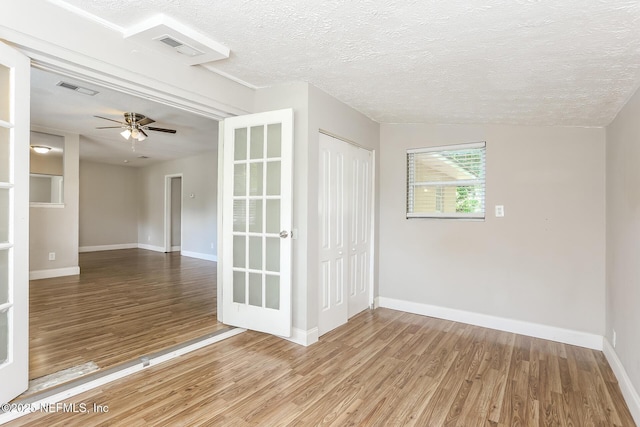 empty room featuring hardwood / wood-style floors, a textured ceiling, and ceiling fan