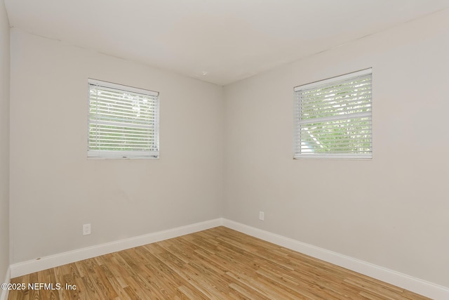 unfurnished room featuring a wealth of natural light and light hardwood / wood-style floors