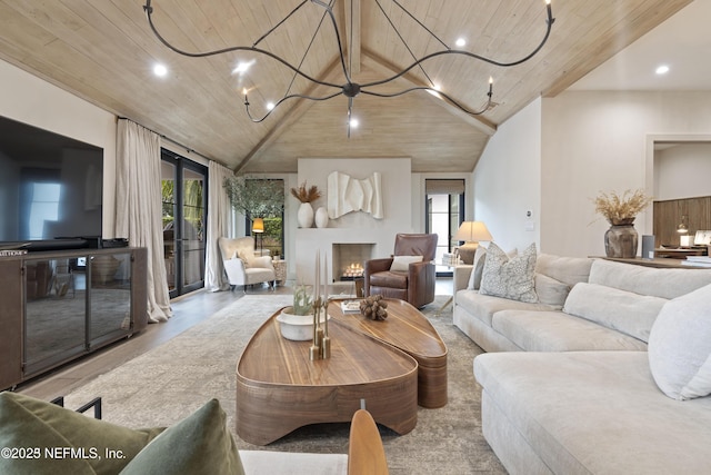 living room with a warm lit fireplace, wooden ceiling, plenty of natural light, and an inviting chandelier