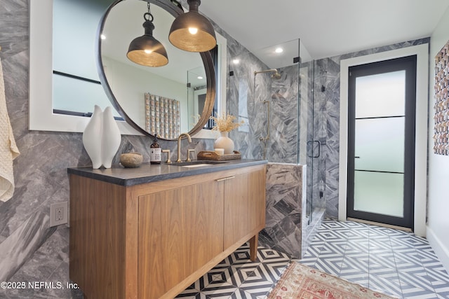 full bathroom with a stall shower, tile walls, vanity, and recessed lighting