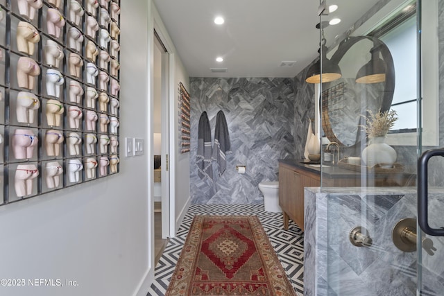 interior space with a shower with shower door, toilet, and recessed lighting