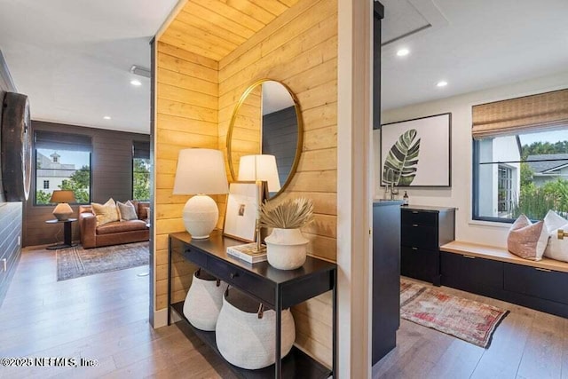 corridor featuring recessed lighting, wooden walls, and wood finished floors