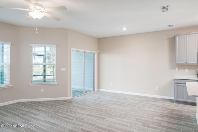 unfurnished living room with ceiling fan, a healthy amount of sunlight, and light wood-type flooring