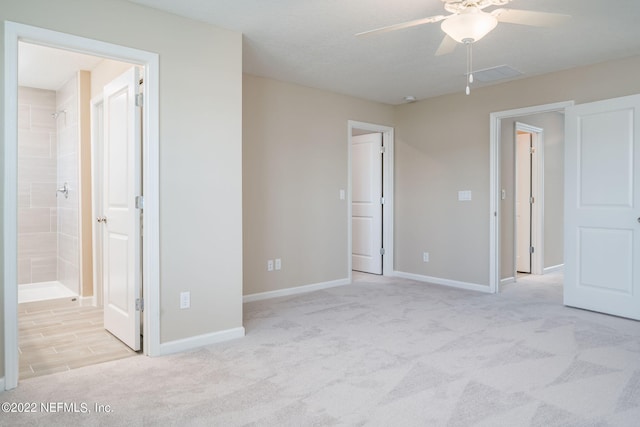 unfurnished bedroom featuring light colored carpet and connected bathroom