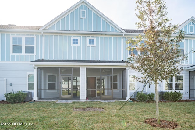 back of property featuring a yard and a sunroom