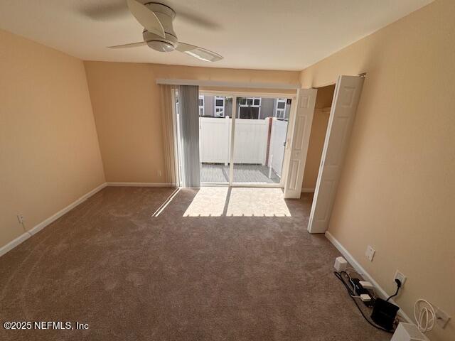 carpeted spare room featuring a wealth of natural light and ceiling fan