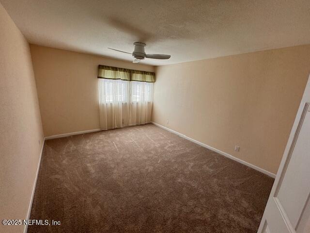 carpeted empty room featuring ceiling fan and a textured ceiling