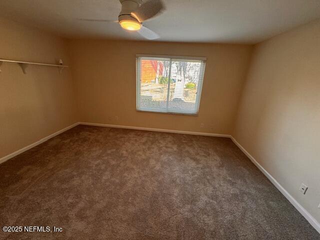 carpeted empty room featuring ceiling fan